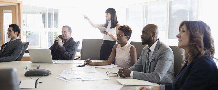Businesswoman with digital tablet leading conference room meeting